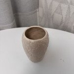 Маленькая бежевая керамическая ваза с вытесненным орнаментом.